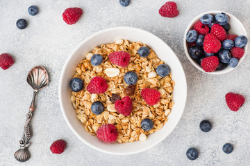 Healthy breakfast. Fresh granola, muesli with yogurt and berries on grey background. Copy space
