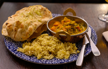 Mangalorean style roasted cauliflower and spinach curry with basmati rice and garlic naan bread, tasty vegetarian food