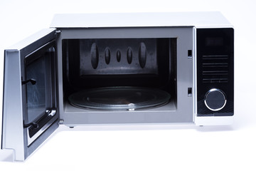 metal and opened microwave oven on white background