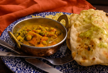 Mangalorean style roasted cauliflower and spinach curry with basmati rice and garlic naan bread, tasty vegetarian food