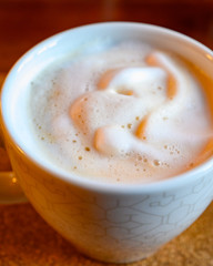 White cup with coffee with white milk foam