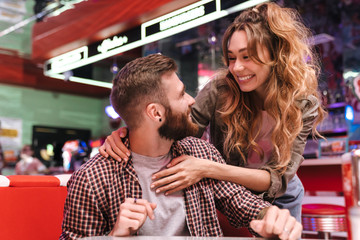 Positive young loving couple in cafe.