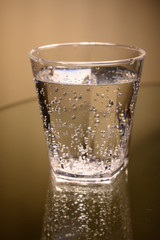 Plastic transparent glass with sparkling water with bubbles