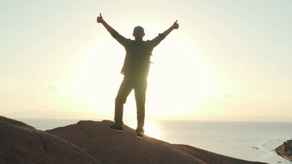 Fototapeta na wymiar Senior traveler raise his hands in success gesture at sunrise