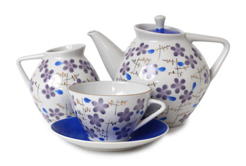 Vintage tea cups and teapot on table. Isolated objects on a white background