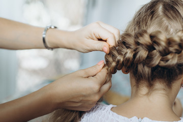 Mother do hair braid to her daughter, close up photo - obrazy, fototapety, plakaty