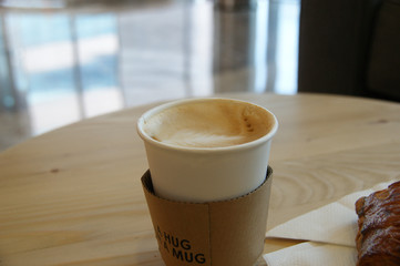 cappuccino in a paper cup with the inscription 