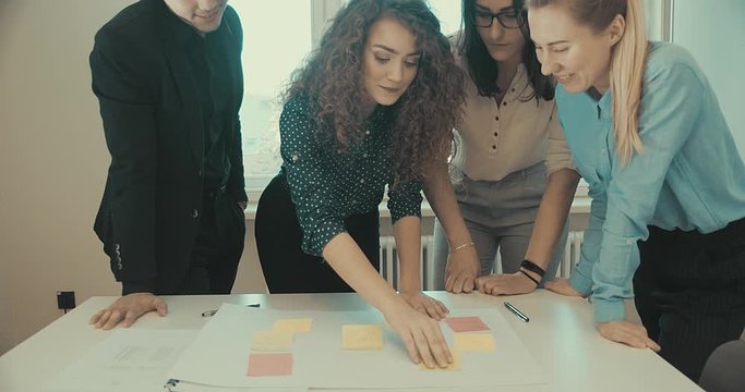 4K slow motion. Discussing of young business people. Mixed race creative team meeting in modern work space. We are stronger together.