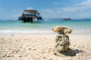Stones arranged on the beach and blurred image boat in sea background,