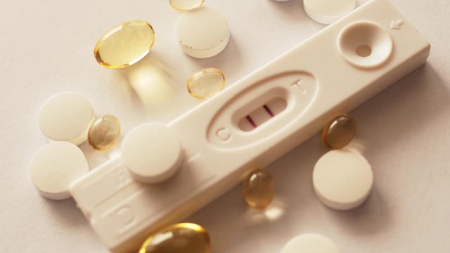 rotating pregnancy test positive, with pills, dietary supplements