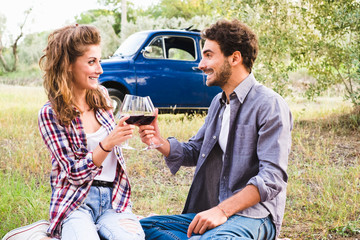 Fototapeta premium Beautiful couple in love having a picnic drinking wine