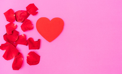 red rose petal and red heart on pink background,