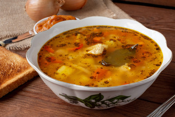 Chicken soup with egg noodles on a wooden background. Lunch. Still-life.