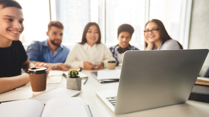 Happy international students preparing for upcoming exams, using laptop