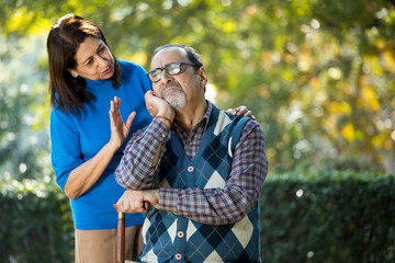 Senior woman comforting her husband suffering with depression at park