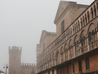 Fototapeta na wymiar Ferrara, Italy. Main square, Torre della Vittoria and Loggia dei Merciai, foggy winter morning.