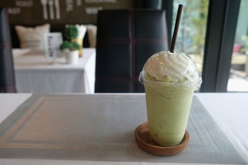 Kiwi smoothie with whipped cream on the restaurant table