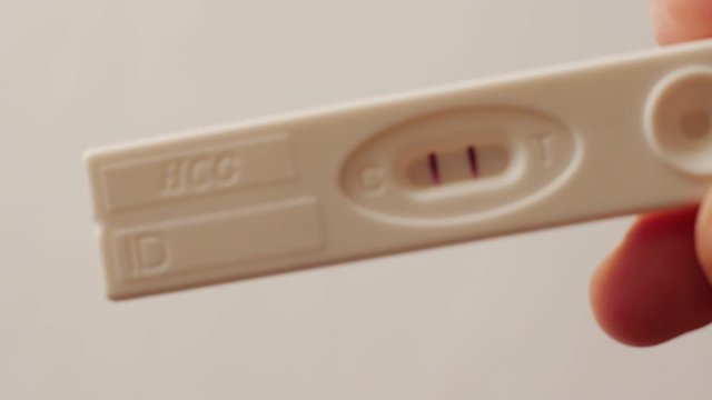 showing positive pregnancy test in hand