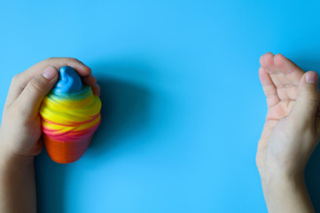 anti stress squishy toy in the form of multicolored ice cream in children's hands on blue background