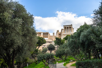 Fototapeta na wymiar Athens, Greece, Acropolis archeological site entrance. Olive trees and ancient architecture.