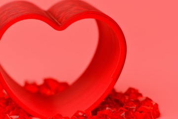 Heart.  Close up red heart on a pink background standing on the fiery red stones. Heart-shaped rainbow. Valentine's day, February 14..