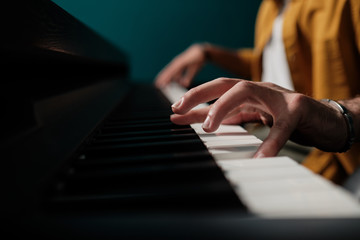 Fototapeta premium Male hands playing keyboard at the studio