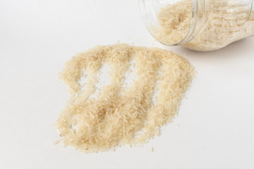 Long white rice on a white background. Spilled from a jar.