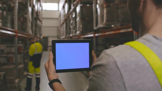 Workers in warehouse using digital tablet