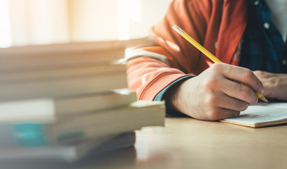 high school,university student study.hands holding pencil writing paper answer sheet.sitting lecture chair taking final exam attending in examination classroom.concept scholarship for education abroad