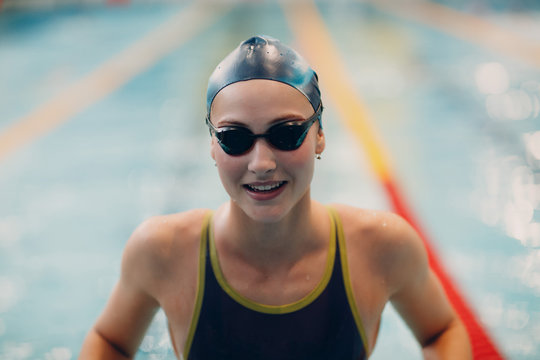 Young smiling girl swimmer in swimming glasses in the pool