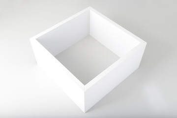 White empty cube on a white, grey background. Four white walls