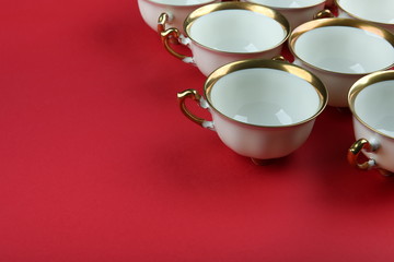 Obraz na płótnie Canvas cups with gilding on a red background with copy space