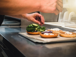 Preparation of burger. Professional chef is preparing burger. Burger making. Cooking hamburger concept.