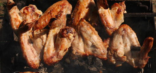 Barbecue grill chicken wings and pork and beef meat .