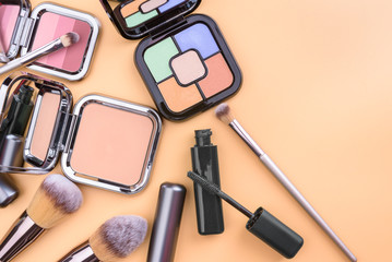 Flat view of cosmetics - lipstic, face-powder, brushes.