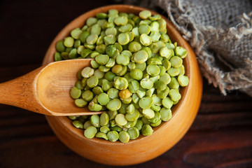 Dried green peas in wooden bowl, top view