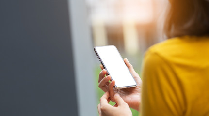 Mockup image blank white screen cell phone.man hand holding texting using mobile on desk at coffee shop.background empty space for advertise text.people contact marketing business,technology 