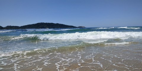 A beautiful view of the sea from Joaquina beach on a sunny day in Florianópolis.