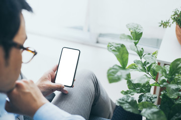 Mockup image blank white screen cell phone.man hand holding texting using mobile on desk at coffee shop.background empty space for advertise text.people contact marketing business,technology 