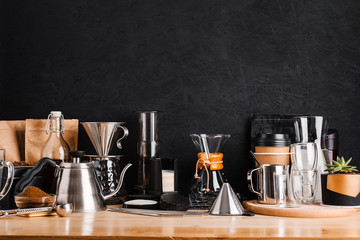 Accessories and utensils for making coffee drinks on a wooden table, coffee shop interior - obrazy, fototapety, plakaty