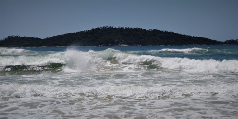 A beautiful view of the sea from Joaquina beach on a sunny day in Florianópolis.