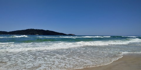 A beautiful view of the sea from Joaquina beach on a sunny day in Florianópolis.
