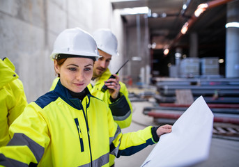 A group of engineers standing on construction site, working.