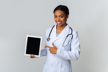 Afro Female Doctor Pointing At Digital Tablet With Blank Screen