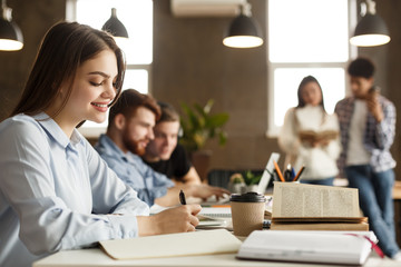 Teen girl doing homework and preparing for final exams at university