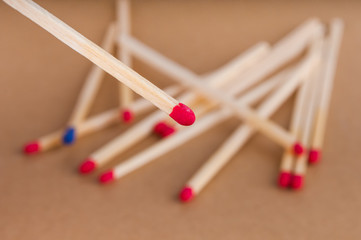 Matchstick close up and few blurred matches on brown background