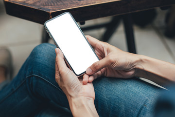 Mockup image blank white screen cell phone.woman hand holding texting using mobile on desk at coffee shop.background empty space for advertise text.people contact marketing business,technology 