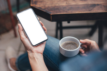 Mockup image blank white screen cell phone.woman hand holding texting using mobile on desk at coffee shop.background empty space for advertise text.people contact marketing business,technology 