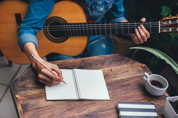 Fototapeta premium artist songwriter thinking writing notes,lyrics in book at studio.man playing live acoustic guitar relax chill.concept for musician creative.composer work process.people relaxing time with instrument