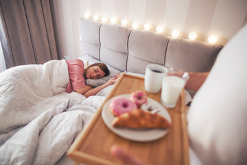 A man brings his girl breakfast to bed.